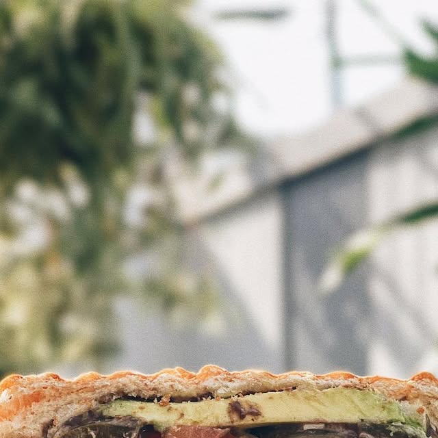 Oaxacan torta sandwich and iced latte with Plantology Cafe branding